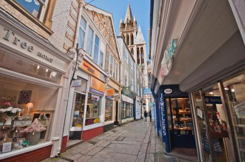 a city street with many shops and buildings at Cornish Cottage - Truro City Centre in Truro