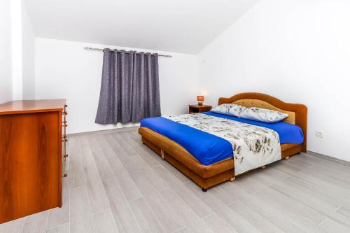 een slaapkamer met een bed en een houten dressoir bij SSM Apartmani in Kotor