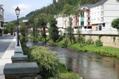 a street light next to a river with buildings at Pensión NAVIA A Pontenova in A Pontenova