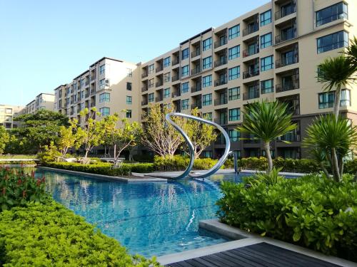 a swimming pool with a metal sculpture in front of a building at Rain​ Cha​ Am​ -​ Hua​ ​Hin​ by​ Good​ Luck​ Home in Cha Am