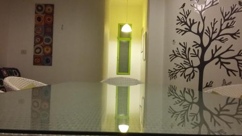 a glass table with a tree on a wall at Casa Roby 120 mt Beach in Fontane Bianche