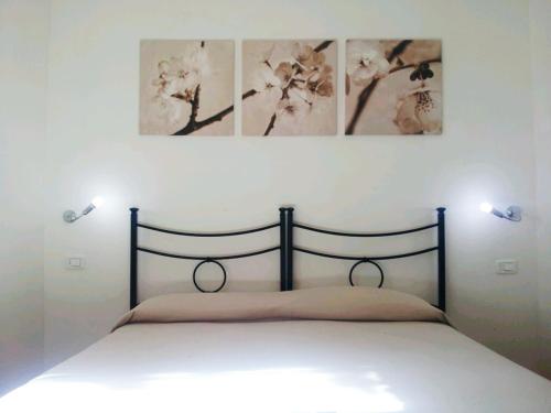 a bedroom with a bed with two pictures on the wall at Luconi Affittacamere in Iesi