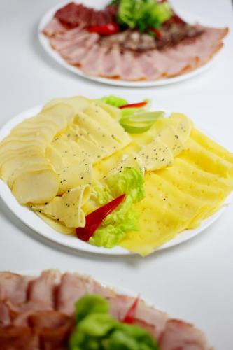 a plate of food with cheese and lettuce and meat at euroHOTEL Katowice Nikiszowiec in Katowice