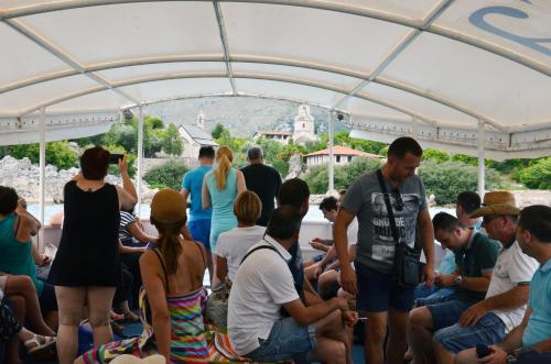 a group of people sitting in a crowd under a tent at Apartmani Konoba Starčevo in Virpazar