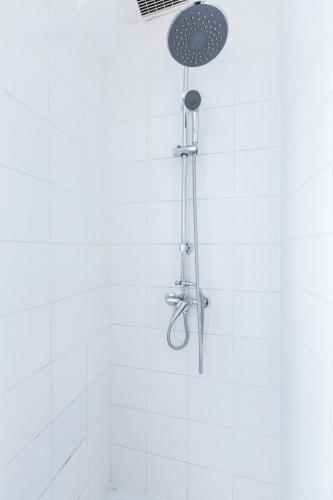 une douche avec pommeau de douche dans une salle de bain dans l'établissement Cosy 40m² near MONTMARTRE, à Paris