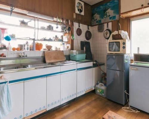 糸島市にある囲炉裏が楽しめる貸切古民家里やのシンクと冷蔵庫付きのキッチン