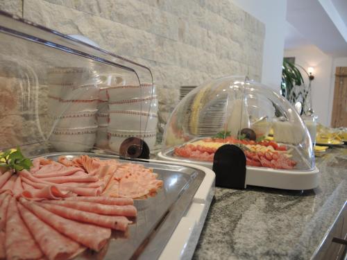 a counter with a bunch of different types of food at Hotel Berghof in Millstatt