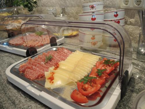 a tray of food with cheese and tomatoes on a counter at Hotel Berghof in Millstatt