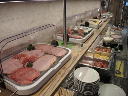 a buffet line with meat and other food items at Hotel Berghof in Millstatt