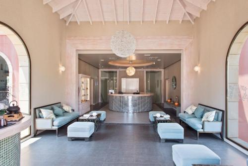 a lobby with blue couches and a bar in the background at Melia Villaitana in Benidorm
