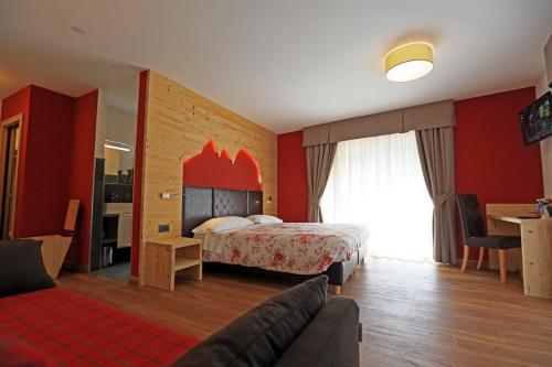 ヴィーゴ・ディ・ファッサにあるHotel San Giovanniのベッドとリビングルームが備わるホテルルームです。