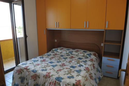 1 Schlafzimmer mit einem Bett mit Blumenbettdecke in der Unterkunft L'arcobaleno in Valledoria