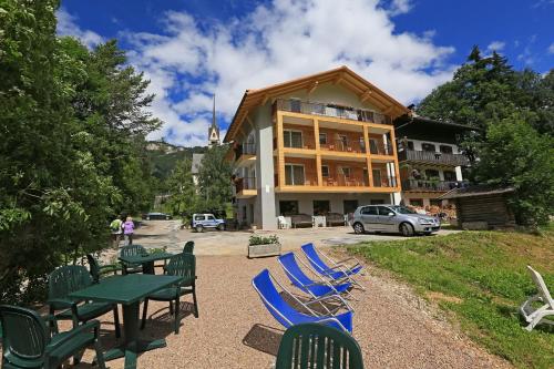 a group of chairs and tables in front of a building at Hotel San Giovanni in Vigo di Fassa
