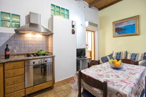 アルゲーロにあるappartamento Gaiaのキッチン(テーブル、コンロ、カウンタートップ付)