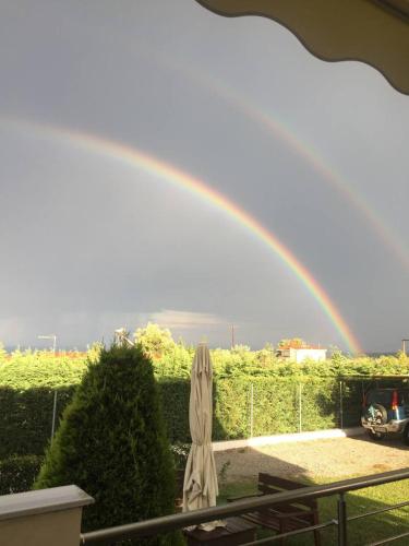 a rainbow over a garden with a umbrella at Plaka Luxury Villa in Litochoro