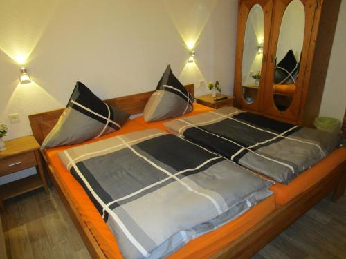 um quarto com uma cama grande e um espelho grande em Ferienhaus "Einfach wohnen" em Beilstein