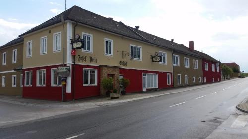 a red and yellow building on the side of a street at Gasthof Polly in Haunoldstein