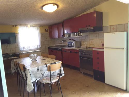 uma cozinha com armários vermelhos e uma mesa com cadeiras em Il balconcino em Montesilvano