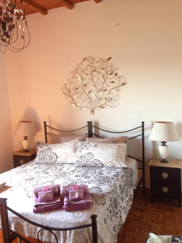 a bedroom with a bed with two purple towels on it at Dolcevita Chianti Apartments in Radda in Chianti