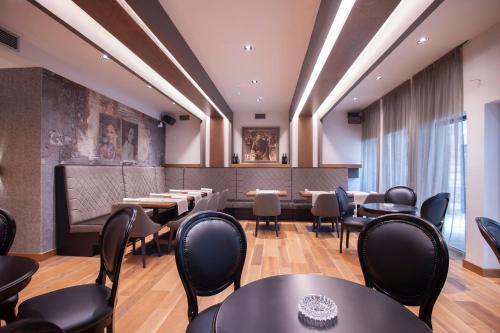 a restaurant with tables and chairs in a room at Hotel Admiral in Budva