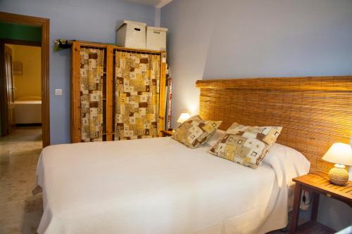 1 dormitorio con 1 cama blanca y 2 almohadas en Apartamento con encanto junto a la playa y en el centro del pueblo, en La Herradura