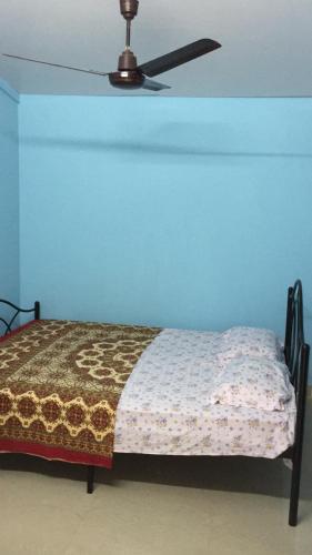 een bed in een kamer met een plafondventilator bij Seashell in Madgaon