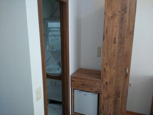 a bathroom with a wooden door next to a sink at Dzveli Batumi in Batumi