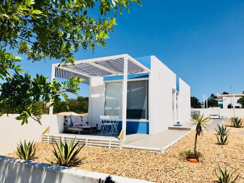una casa bianca con tenda da sole sulla spiaggia di Comporta Natura & Beach a Tróia