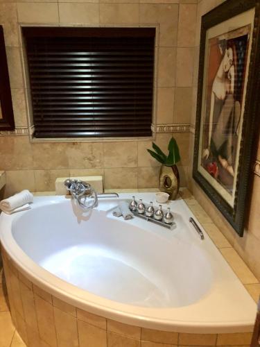 a large bath tub in a bathroom with a window at Spacube Luxury Suites and Spa in Pretoria