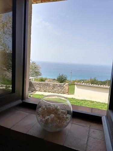 a bowl sitting on a window sill with a view of the ocean at Il Cerro Agriturismo Zagarese in Fuscaldo