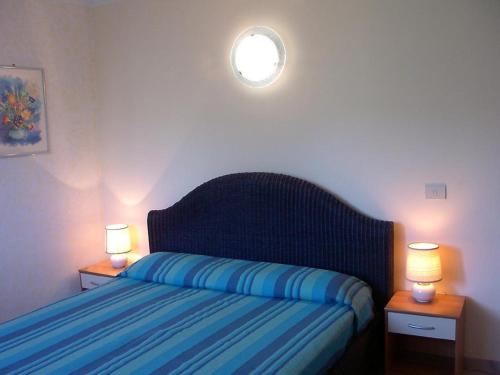sypialnia z łóżkiem i dwoma lampkami na dwóch stołach w obiekcie Casa Blu w mieście Imperia