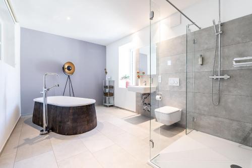a bathroom with a bath tub and a shower at Parkside Boutique Appartements in Herbolzheim