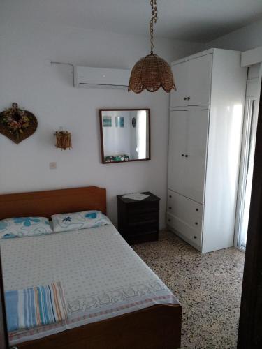 a bedroom with a bed and a dresser and a mirror at Grigorios Apartments in Nea Vrasna