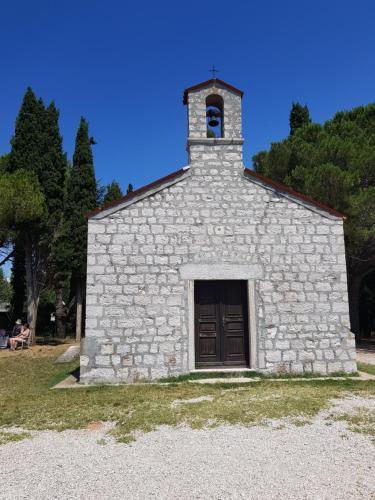 a small stone church with a door and a bell at Mediterranean Beach House in Umag