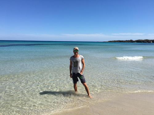 a man standing in the water on the beach at Villa oasi in Fontane Bianche