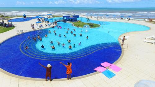 a swimming pool with people in it at Makai Resort All Inclusive Convention Aracaju in Aracaju