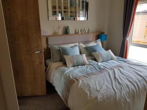 a bedroom with a bed with pillows on it at Hot tub hols in Bear Lodge with roof terrace in Tattershall