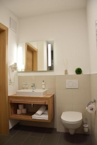 a bathroom with a sink and a toilet and a mirror at Vida Armonia in Ischgl