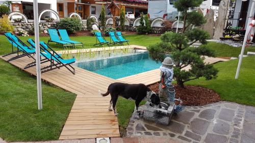 a dog drinking water from a bucket next to a pool at ALPENHOTEL TYROL - B&B - ADULTS ONLY - Alpines Lifestyle-Konzepthotel - dog friendly in Pertisau