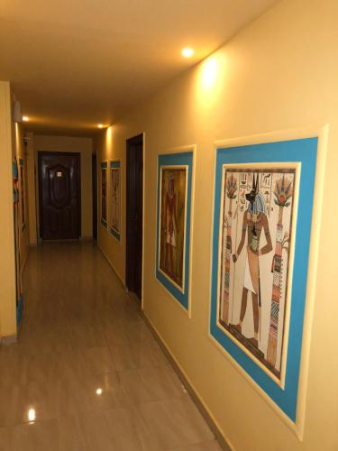 a hallway with paintings on the walls at Great Pyramid Inn in Cairo