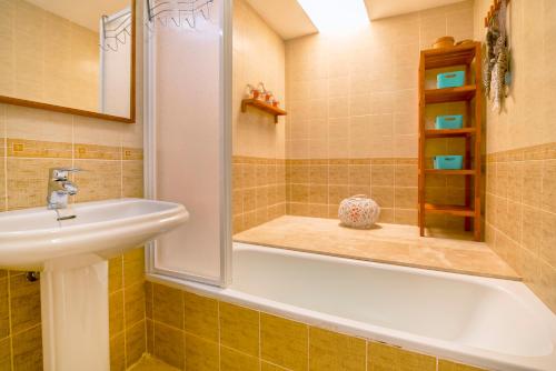 a bathroom with a bath tub and a sink at Bungalow el Valle in Puerto Rico with Jacuzzi in Puerto Rico de Gran Canaria