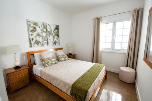 a bedroom with a bed and a window at Seaside Azores Villa with natural pool, terrace & barbecue in Capelas