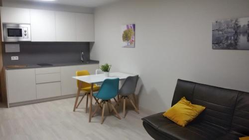 a living room with a couch and a table and chairs at O balcón da ribeira in Parada del Sil