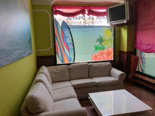 桑托納的住宿－Albergue Turistico Playa de Berria，客厅配有沙发和桌子
