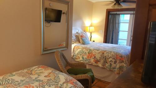 a hotel room with two beds and a mirror at Courtney's Place Historic Cottages & Inns in Key West