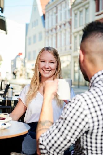 a woman sitting at a table drinking a cup of coffee at Hotel Hansa in Herford