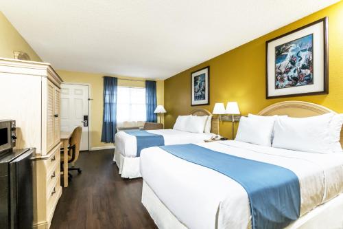 a hotel room with two beds and a television at Days Inn by Wyndham Madison in Madison
