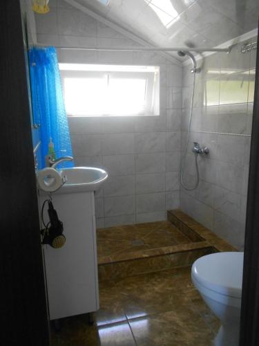 uma casa de banho com um lavatório, um WC e uma janela. em квартира-студия в г. Кропивницком (Кировограде) em Kirovohrad