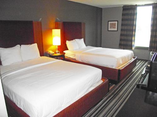 a hotel room with two beds and a window at Travelodge by Wyndham Memphis Airport/Graceland in Memphis