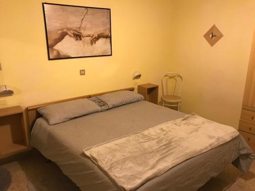 リミニにあるDependance Hotel Villa Meropeのベッドルーム1室(ベッド1台付)が備わります。壁に絵が飾られています。